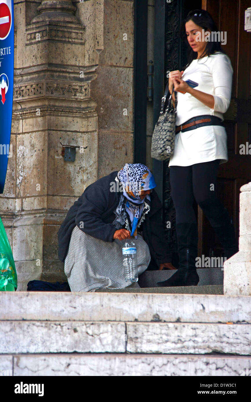 Muslimische Frau bittet als intelligente weibliche Touristen vorbei am Eingang zum Sacre Coeur Montmartre Paris Frankreich Europa geht Stockfoto