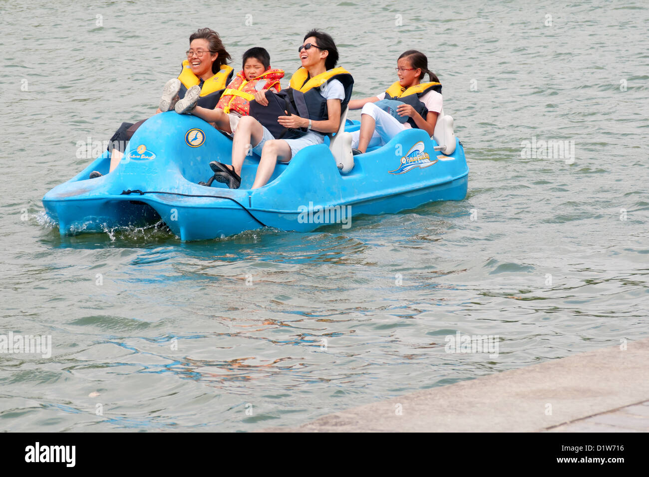 Auf dem Wasser, Paddel-Bootsfahrt von einigen Touristen, die Spaß an einem kalten Tag Flickschusterei Stockfoto