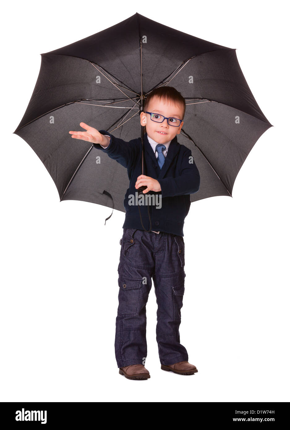 Junge in schwarzer Kleidung unter großen schwarzen Regenschirm überprüfen, es regnet oder nicht. Isoliert auf weiss Stockfoto