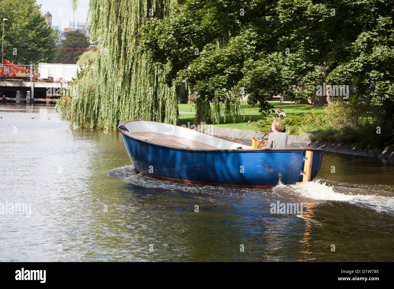 Boot gleiten flussabwärts in Amsterdam an einem warmen sonnigen Tag Stockfoto