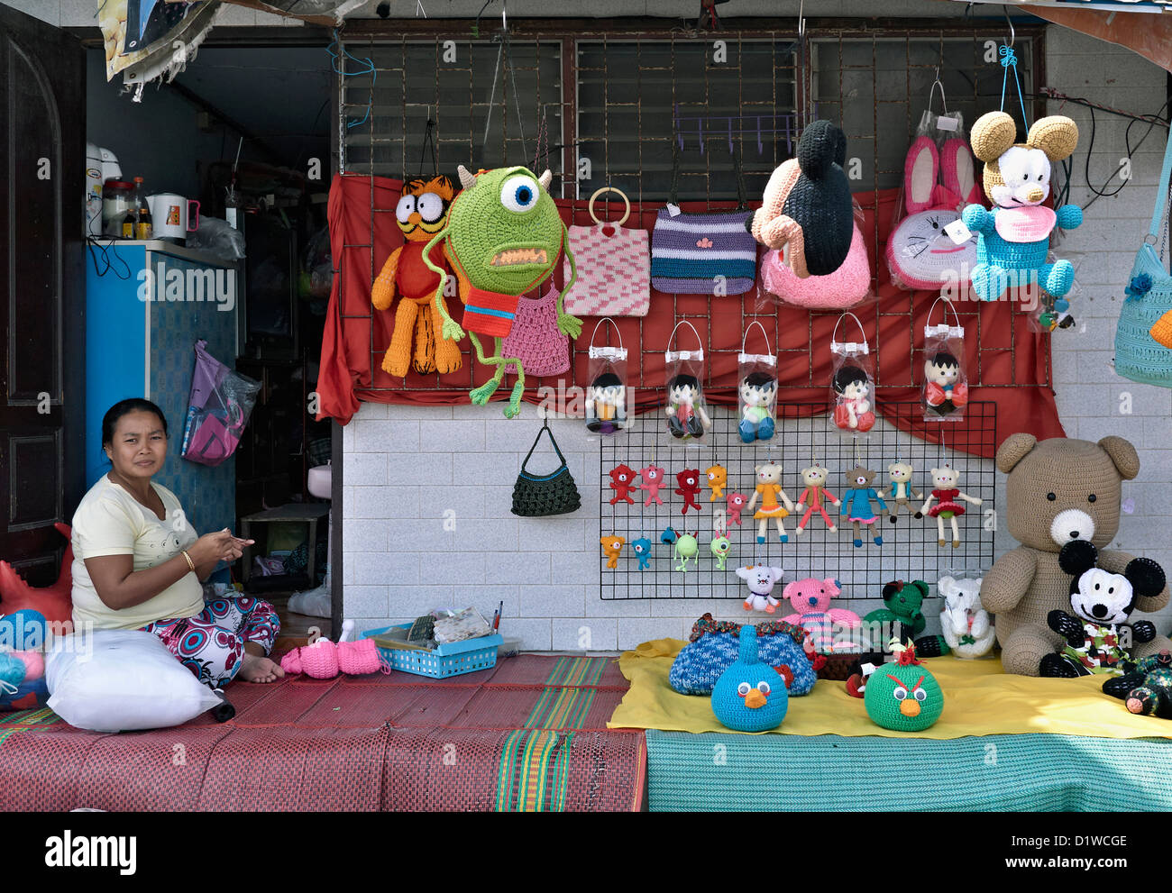 Thai Frau Anzeigen von Hand gemacht weichen Kinderspielzeug für den Verkauf außerhalb ihrer Heimat. Thailand-Leute von zu Hause aus arbeiten. S. E. Asien Stockfoto