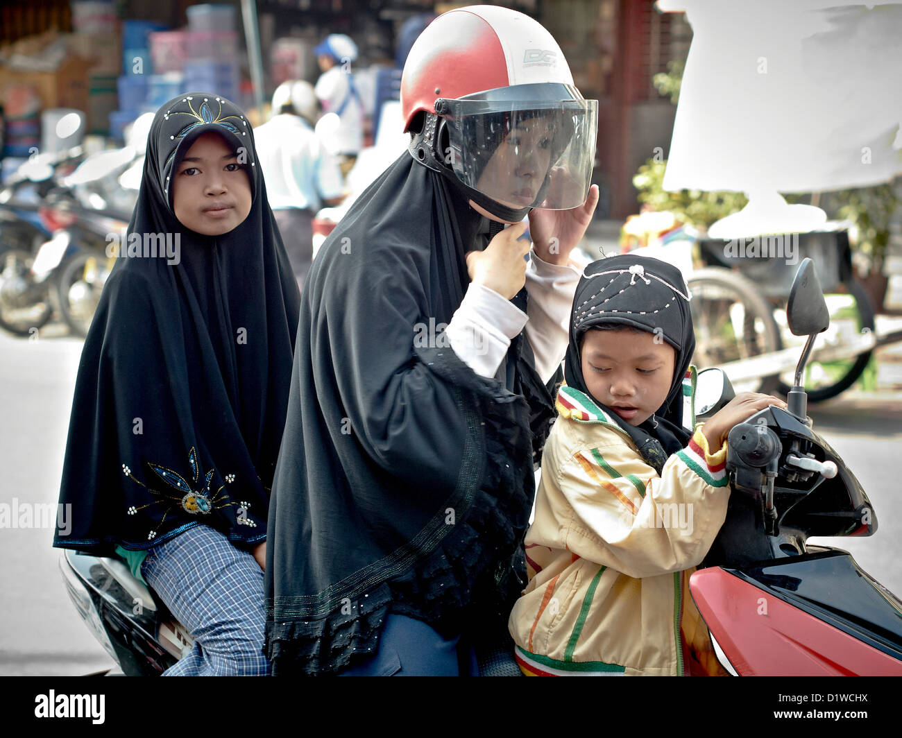 Thai muslimische Mutter und Kinder auf einem Motorrad. S. E. Asien Thailand Stockfoto