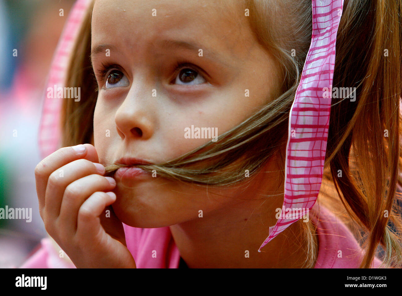 Kleines Mädchen mit den Haaren im Mund, Kindergesichtsausdruck Stockfoto