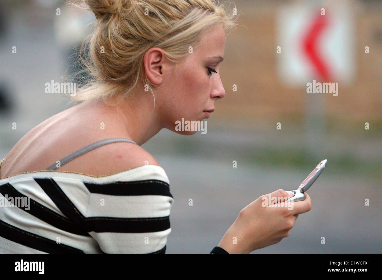 Junge Frau mit Handy in Verbindung, SMS-Nachricht, Blick auf die Straße Stockfoto
