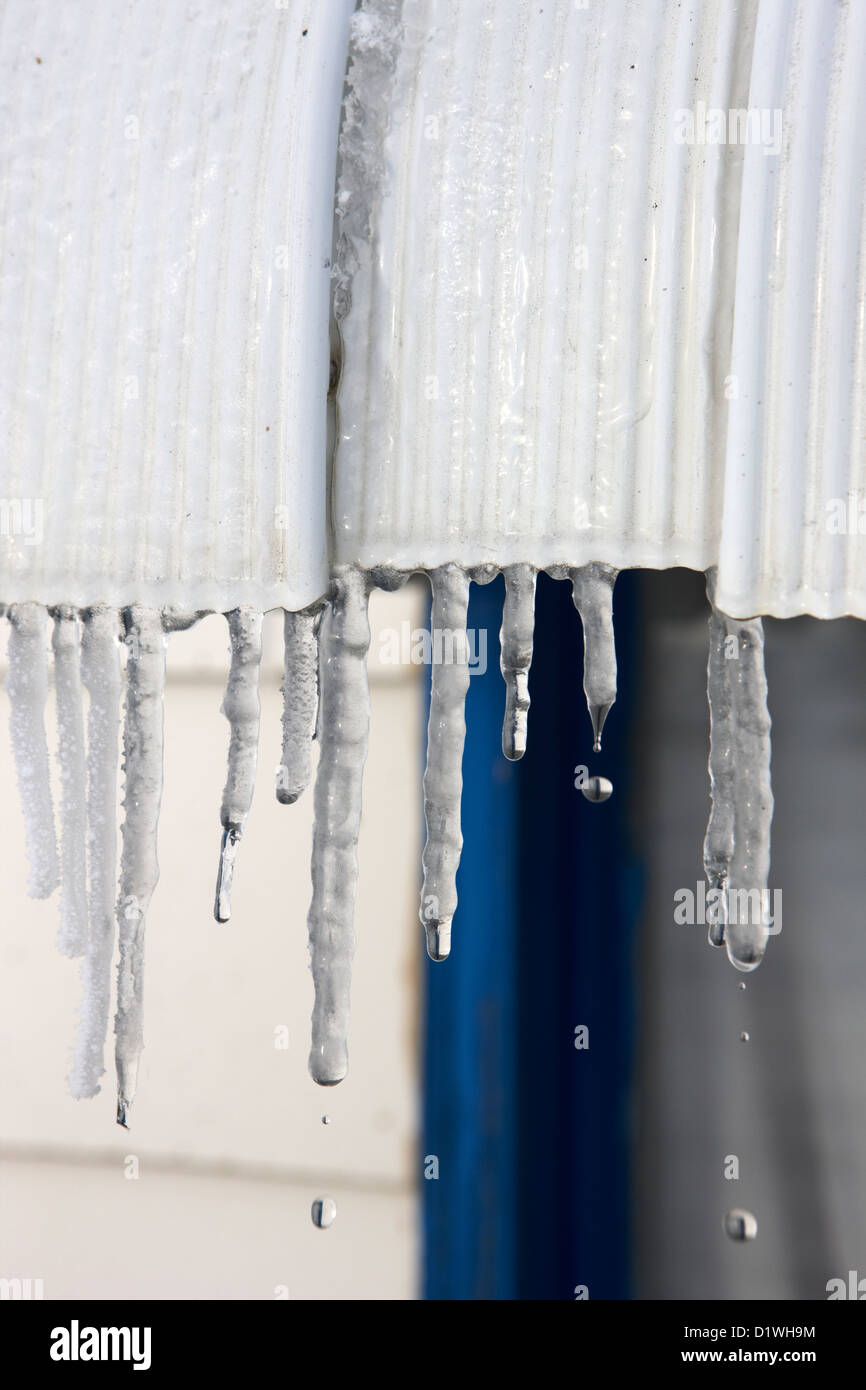 Wasser tropft aus Eiszapfen auf ein Haus, bei Sonnenschein in Forget Saskatchewan Kanada schmelzen Stockfoto