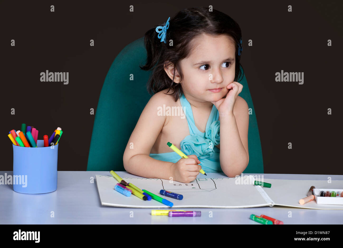 Kleines Mädchen denken während des Zeichnens Stockfoto