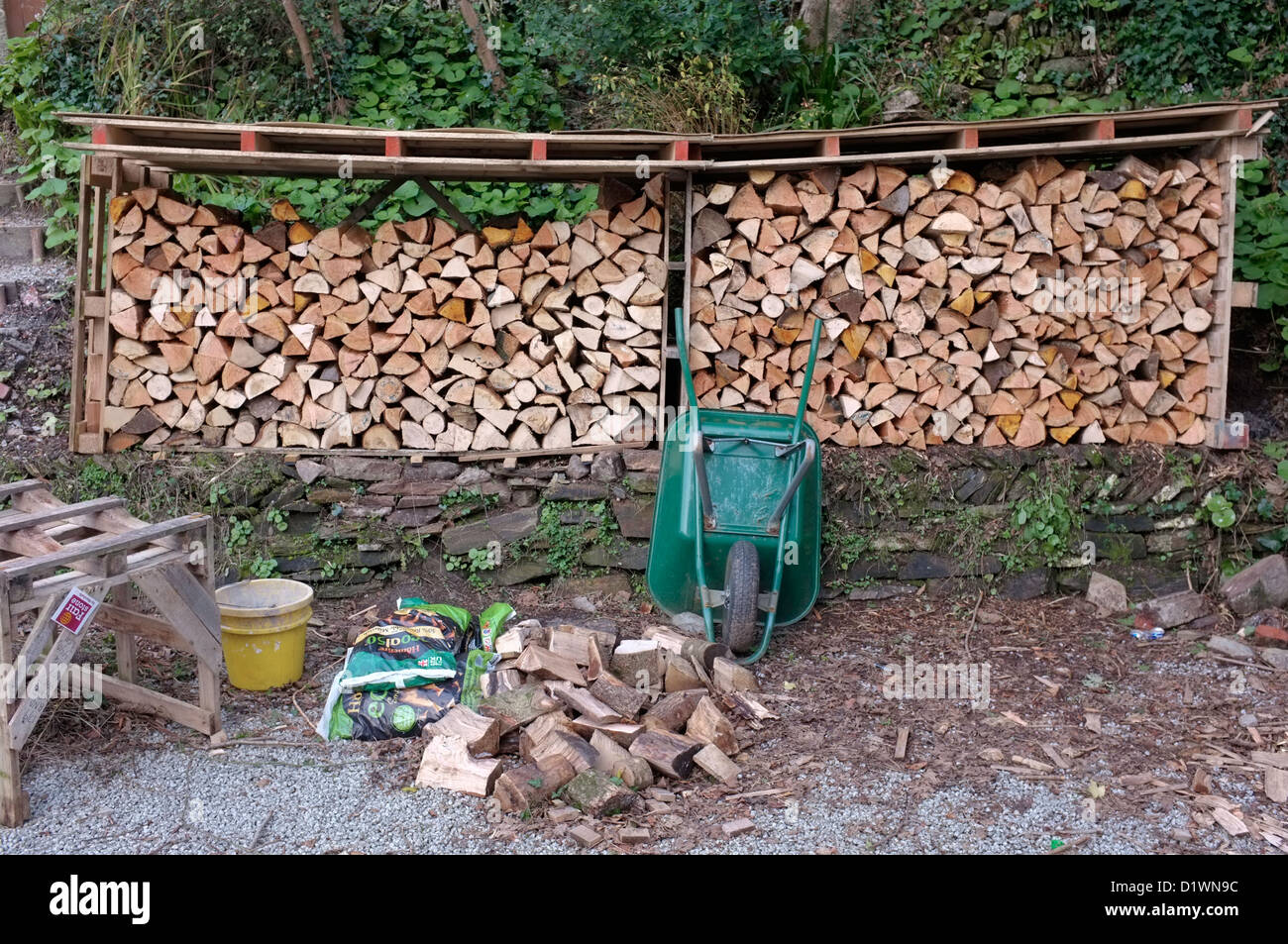 Gehackte, gestapeltes Holz mit Paletten verwendet, um ein Cover erstellen Stockfoto
