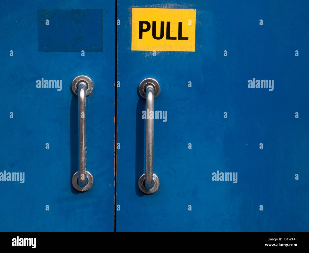 Gelbe "Pull" anmelden blauen Türen mit Metallgriffen Stockfoto
