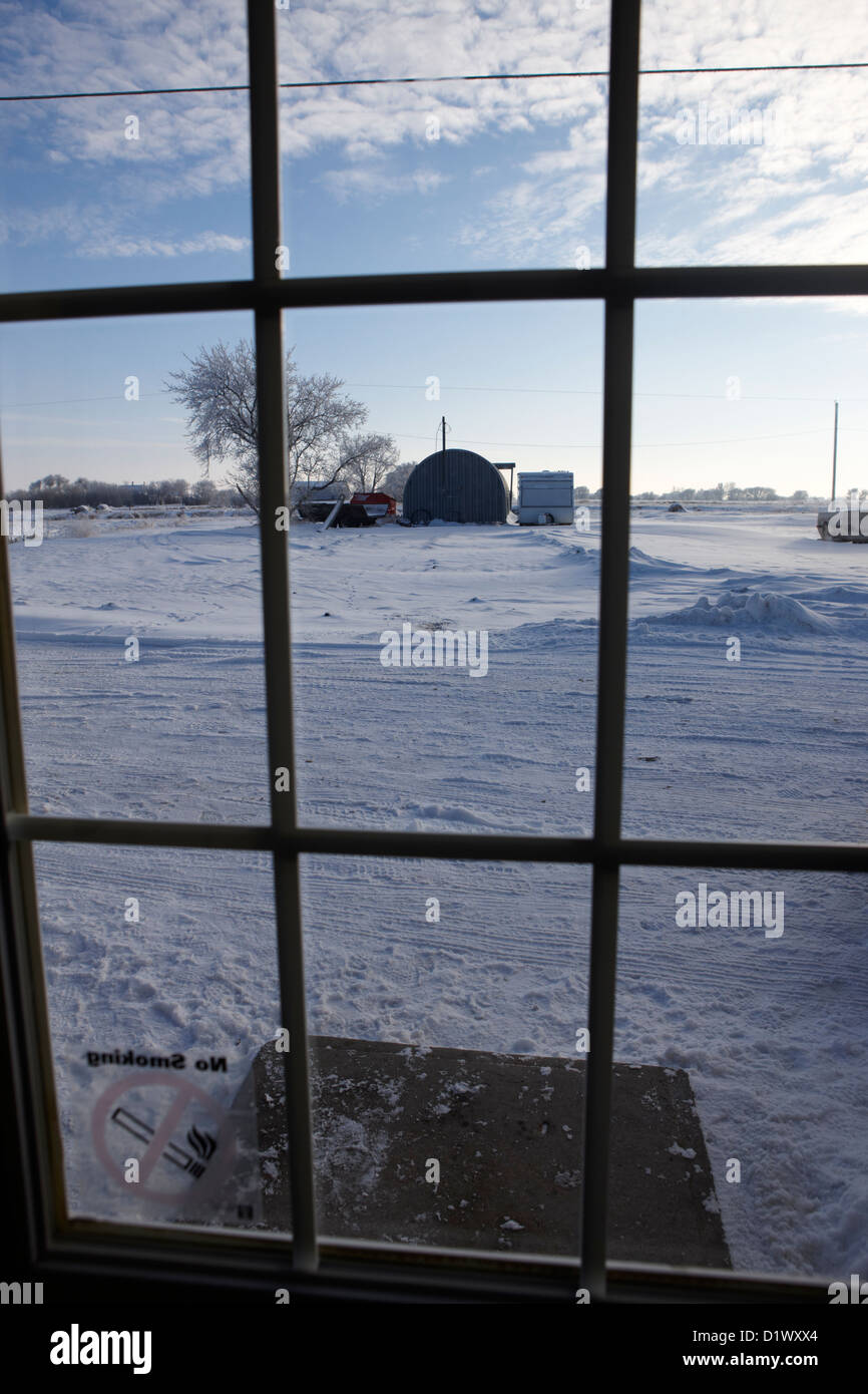 Blick durch Türfenster und Schnee bedeckte Szene in kleinen ländlichen Dorf vergessen Saskatchewan Kanada Stockfoto