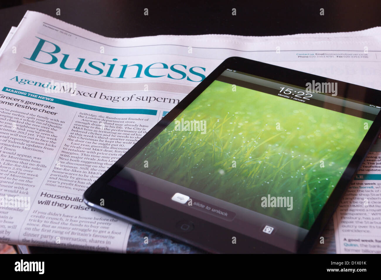 Ein Apple iPad Mini steht eine Wirtschaftszeitung Stockfoto