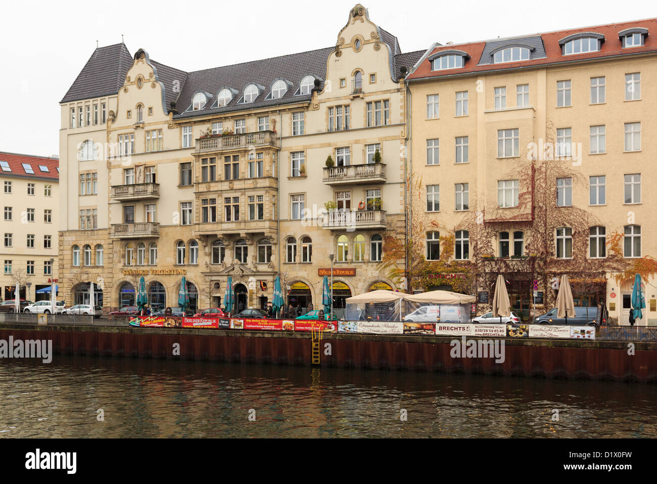Elegant am Flussufer Gebäude mit Restaurants und Bars am Schiffbauerdamm aus über die Spree in Berlin, Deutschland Stockfoto