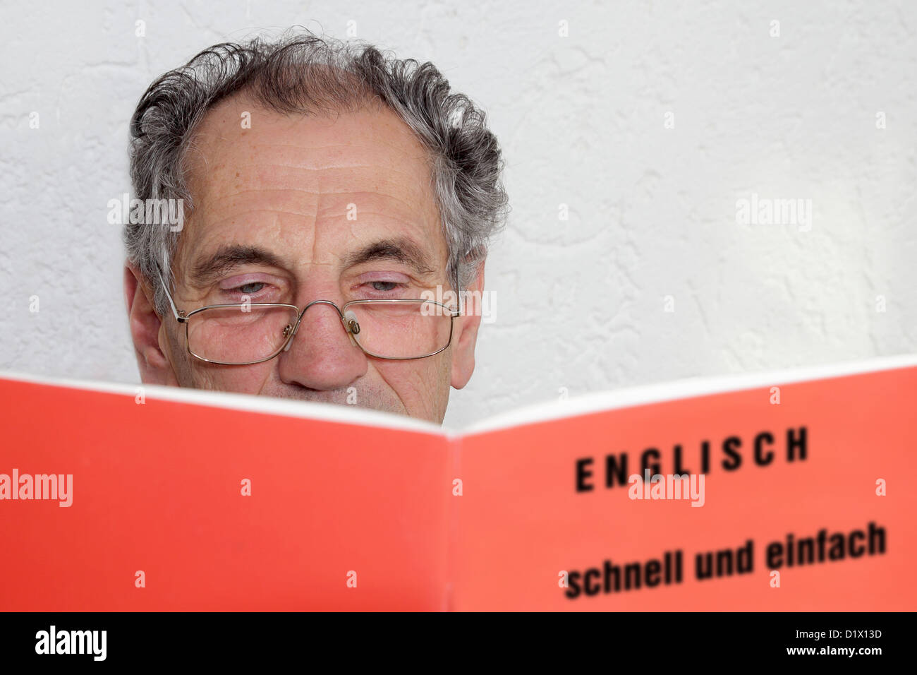 Senior, Erlernen der englischen Sprache ein Buch zu lesen Stockfoto