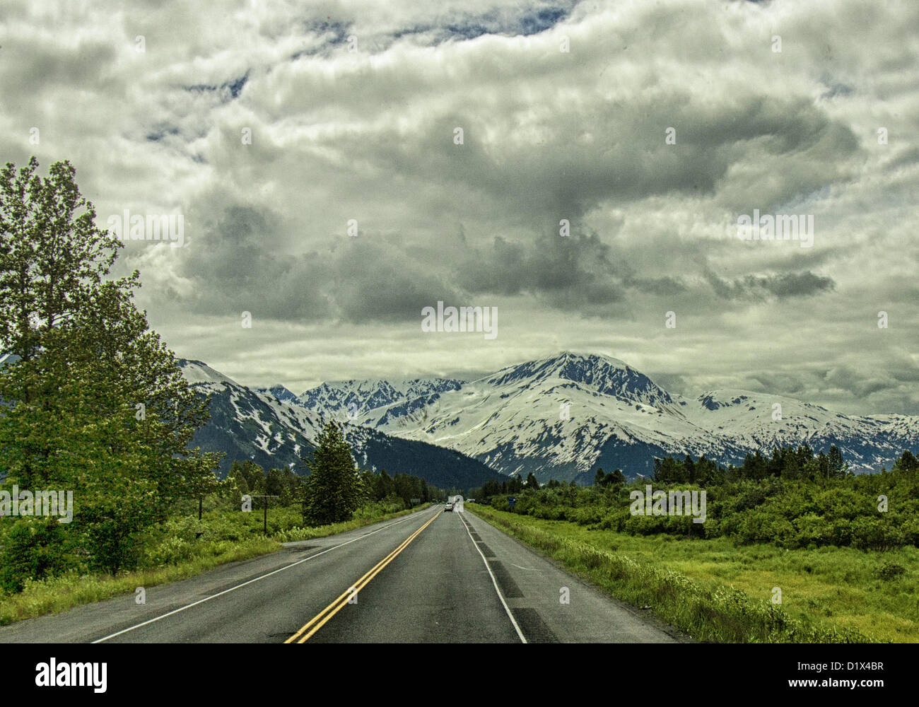 29. Juni 2012 - Halbinsel Kenai, Alaska, USA - nähert sich einer imposanten schneebedeckten Bergkette fahren Süden an malerischen Seward Highway im Chugach National Forest. Bezeichnet einen National Forest Scenic Byway, ein All-American Road und eine Alaska Scenic Byway, läuft Seward Highway 127 Meilen [204 km] von Anchorage, Seward, Kenai-Halbinsel, Chugach State Park und Chugach National Forest, ein Schaufenster für natürliche Schönheit und Vielfalt der Landschaften in Süd-Zentral-Alaska. (Kredit-Bild: © Arnold Drapkin/ZUMAPRESS.com) Stockfoto