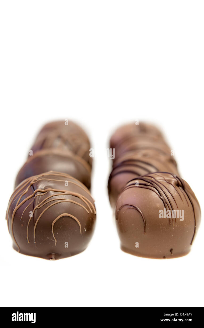 Zwei Reihen von dunklen und Milchschokolade Trüffel Praline geringe Schärfentiefe Isolated on White Background Stockfoto