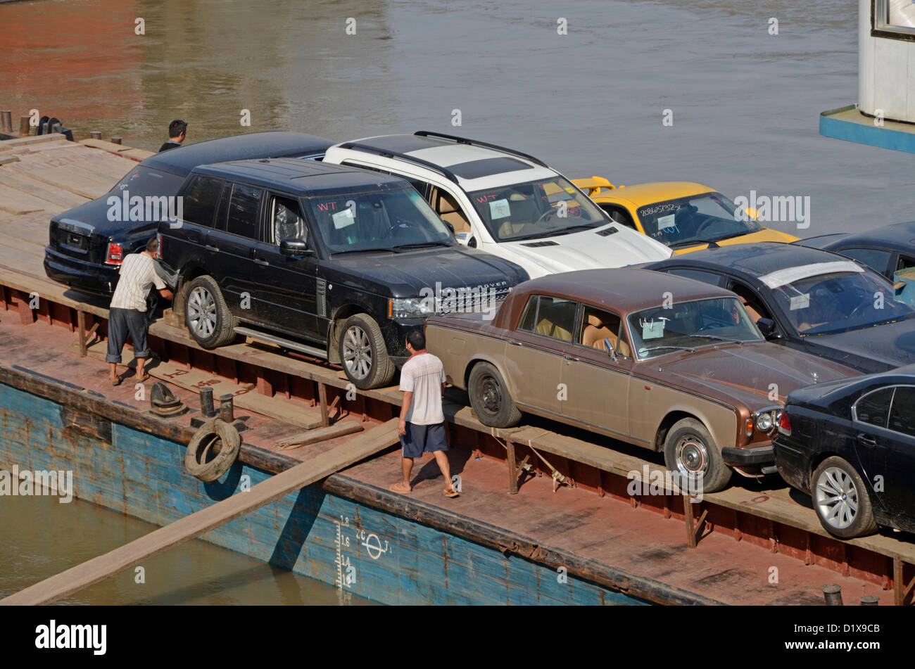 Einem chinesischen Frachter bei Chiang Saen, Thailand tragen Oldtimer nach China. Dazu gehören Rolls-Royce, Range Rover und Posche Modelle. Das Schiff segelt auf dem Mekong in der Provinz Yunnan mit einer gemischten Ladung. Stockfoto