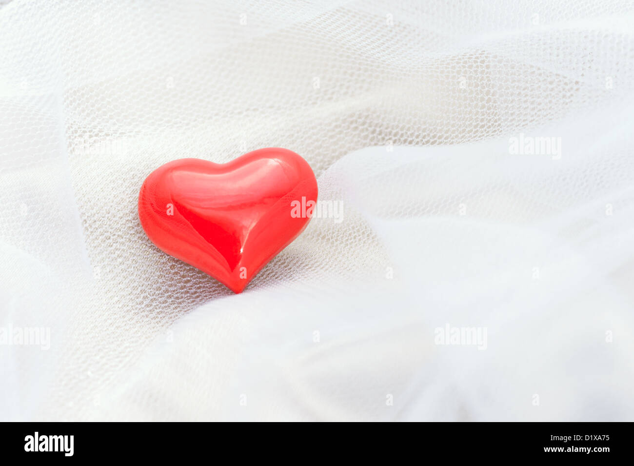 Rotes Herz auf einem weißen Schleier für romantische Anlässe aller Art Stockfoto