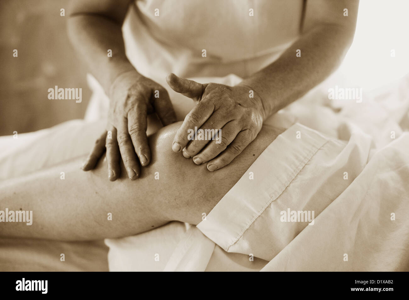 Bodyworker starke sanfte Hände arbeiten mit einem Patienten-Knie. Stockfoto