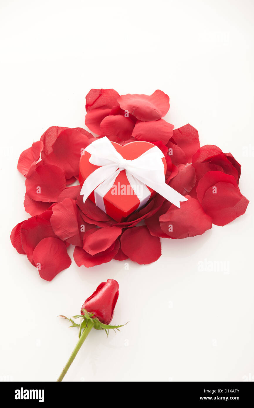 Valentinstag Geschenk im roten Kasten mit Rosenblättern, isoliert auf weiss Stockfoto