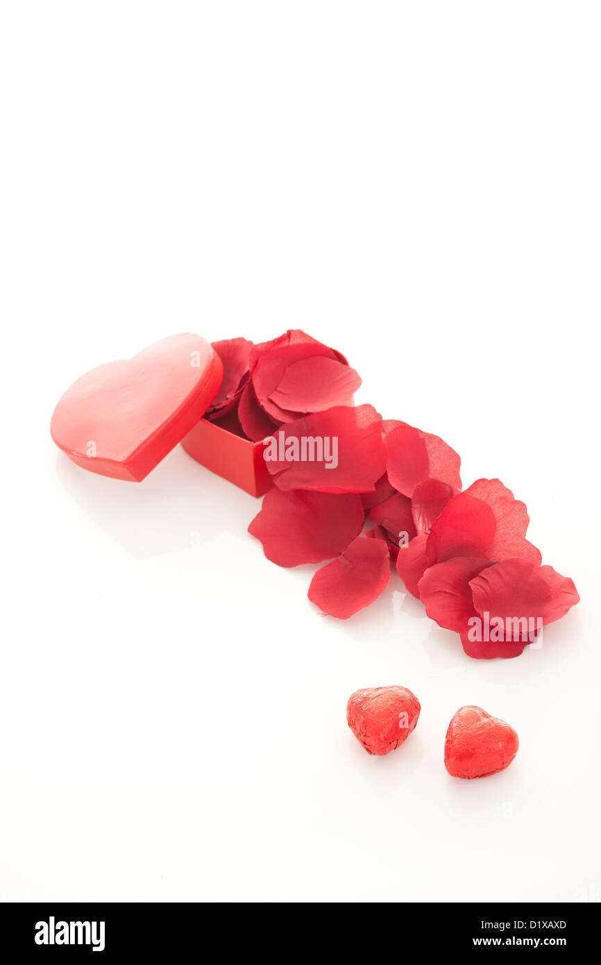 Valentinstag Geschenk im roten Kasten mit Rosenblättern, isoliert auf weiss Stockfoto