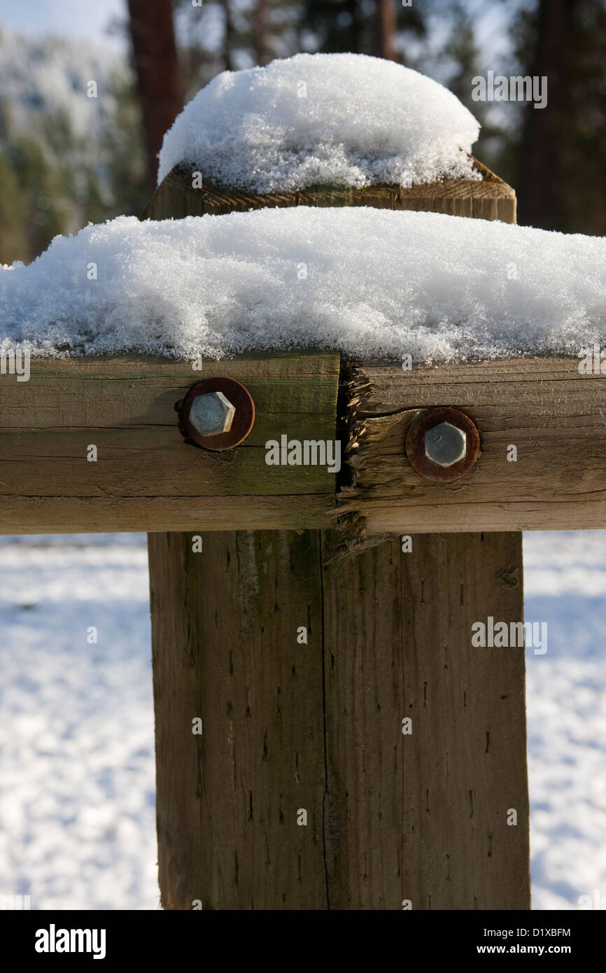 Schnee bedeckt auf einem Holzzaun-Post. Stockfoto