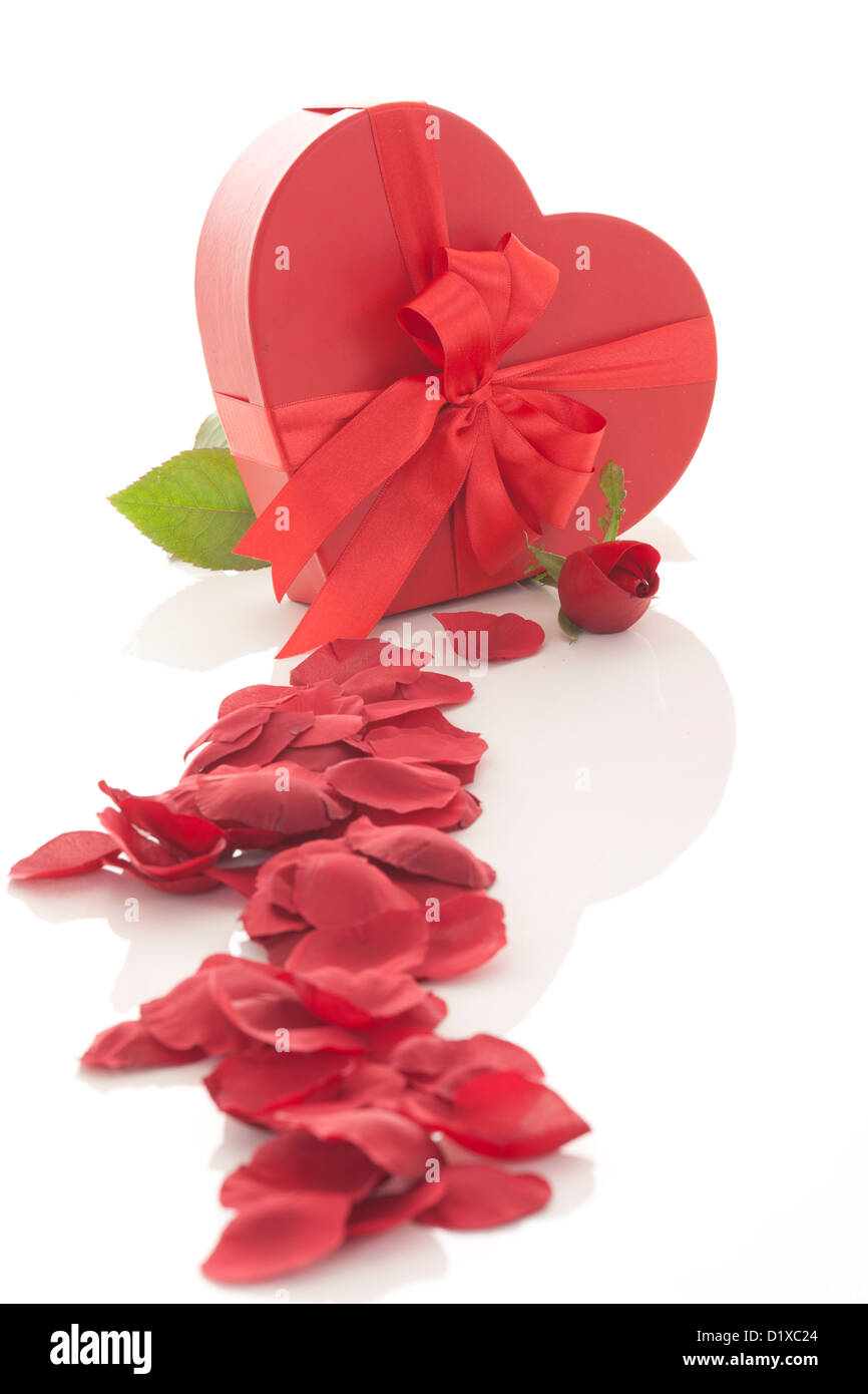 Valentinstag Geschenk im roten Kasten mit Rosenblättern, isoliert auf weiss Stockfoto