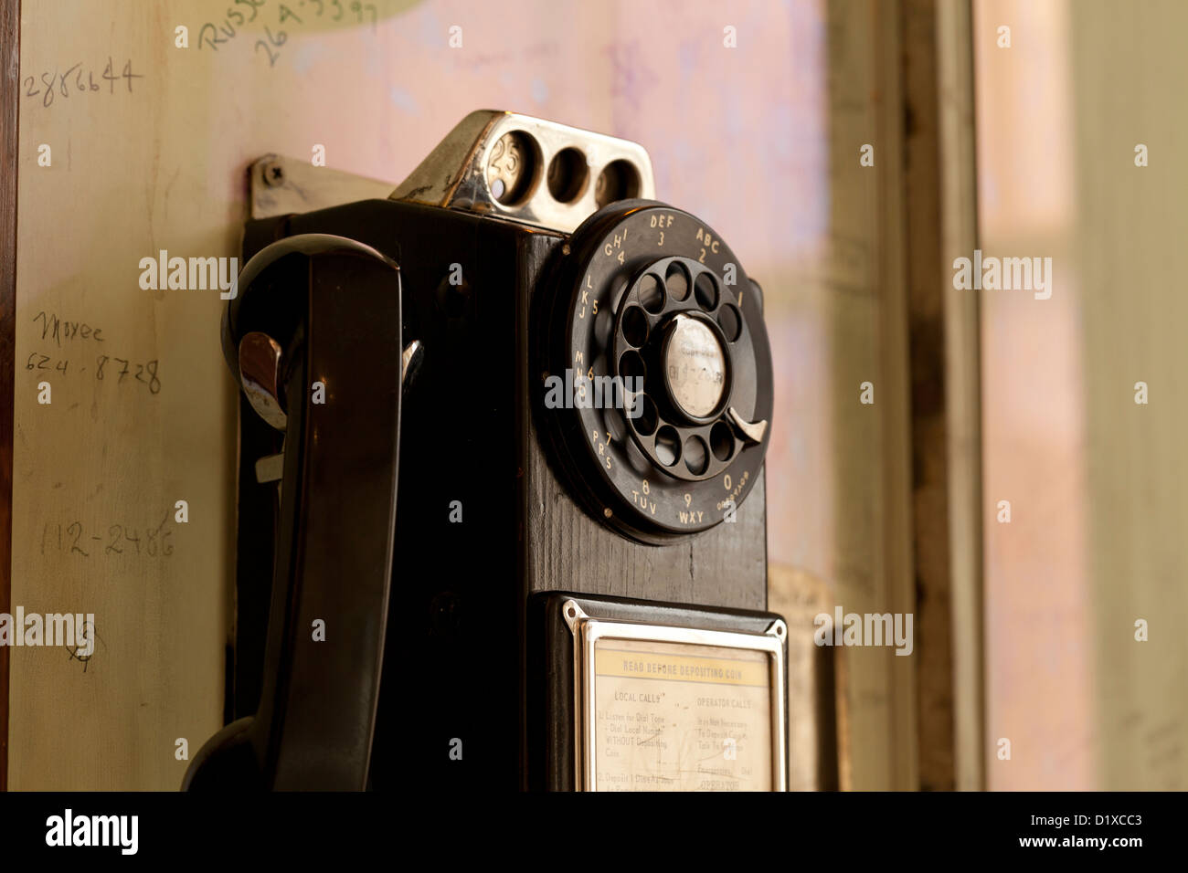 Vintage Wählscheibe Münztelefon auf Wand Stockfoto
