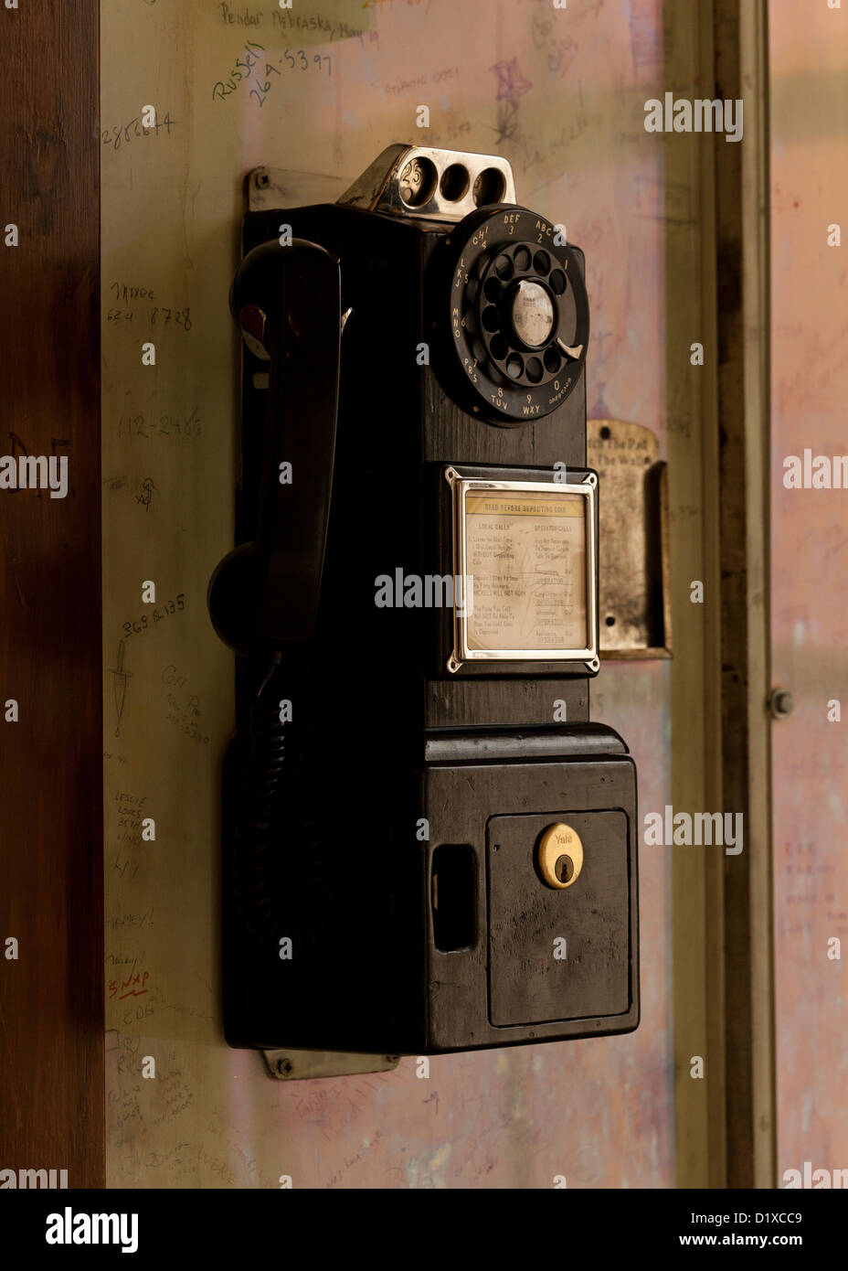 Vintage Wählscheibe Münztelefon auf Wand Stockfoto