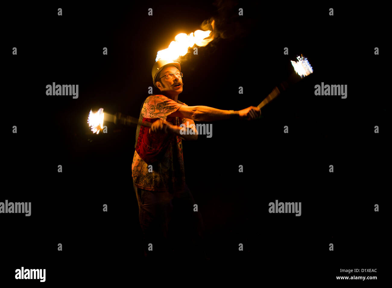 Ein Mann, Jonglieren mit Feuer Flammen - Party Entertainer, Nacht, UK Stockfoto