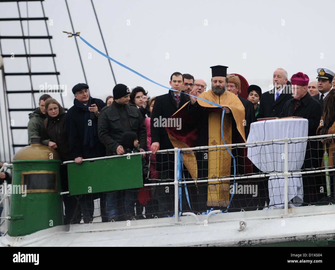 Bischöflicher Vikar Erzpriester Georgios Manos (M, gelbe Gewand) und Erzpriester Werner Thissen (2-R) führen die traditionellen großer Segen des Wassers an Bord der großen Segelschiff "Rickmer Rickmers" in Hamburg, Deutschland, 6. Januar 2013. Der Pfarrer segnete das Wasser der Elbe und den Gewässern der göttlichen Schöpfung. Foto: Angelika Warmuth Stockfoto