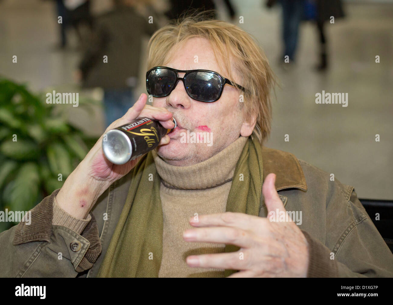 Schauspieler Helmut Berger nimmt einen Reißverschluss aus seiner Flasche am Flughafen in Frankfurt Am Main, Deutschland, 6. Januar 2013. Sie lassen für den australischen Dschungel-Camp von der deutschen Reality-Show Ich bin Ein Star   Holt mich Hier Raus! (Ich bin ein Star – holt mich hier raus!). Foto: Frank Rumpenhorst Stockfoto