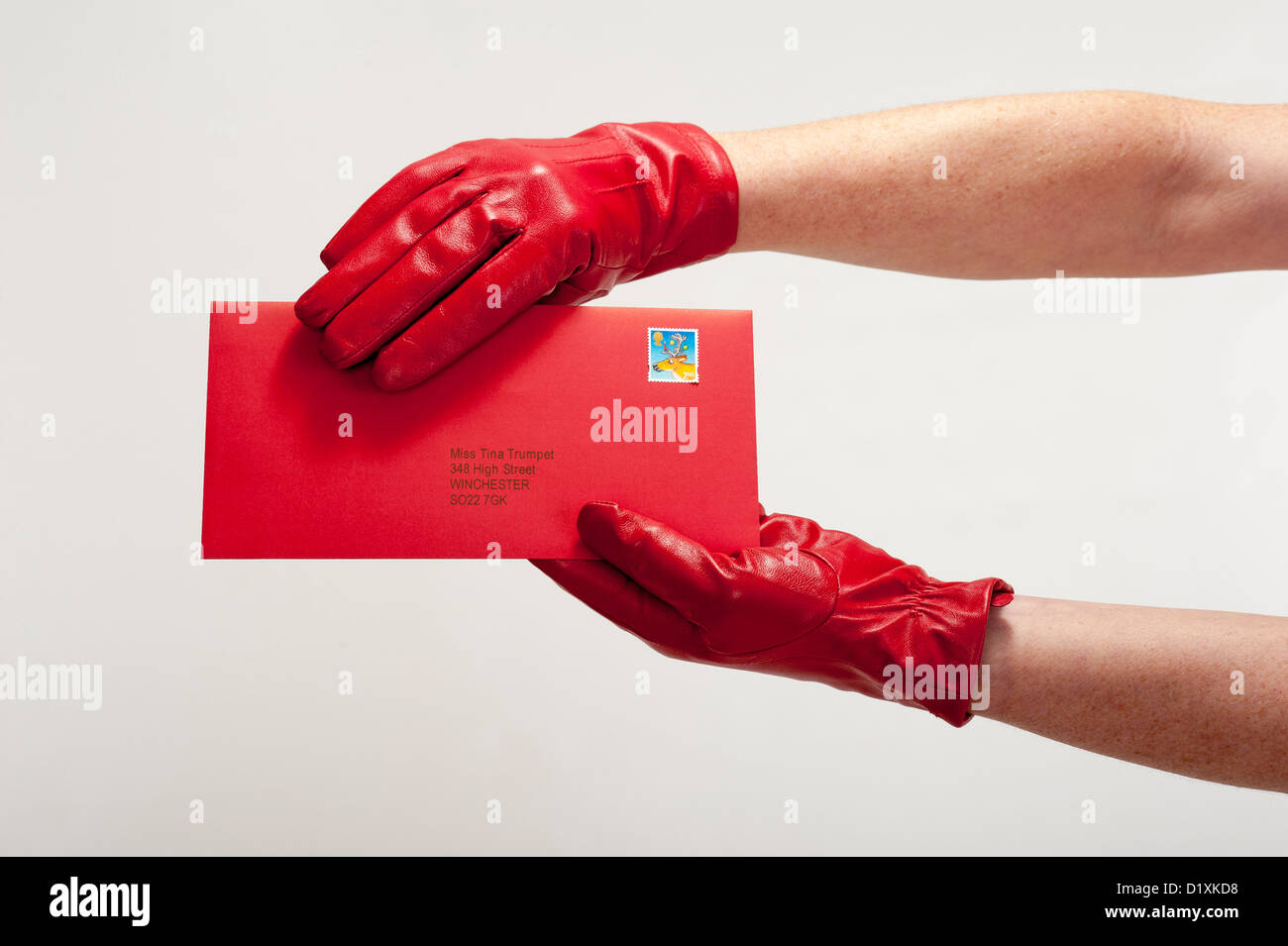 Red Letter Day Frau rot behandschuhte Hand hält eine wichtige Mitteilung Stockfoto
