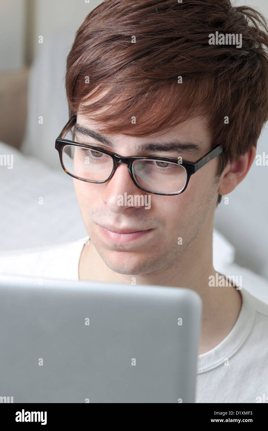 Junger Mann mit Brille, die einem Computer-Bildschirm betrachten. Stockfoto