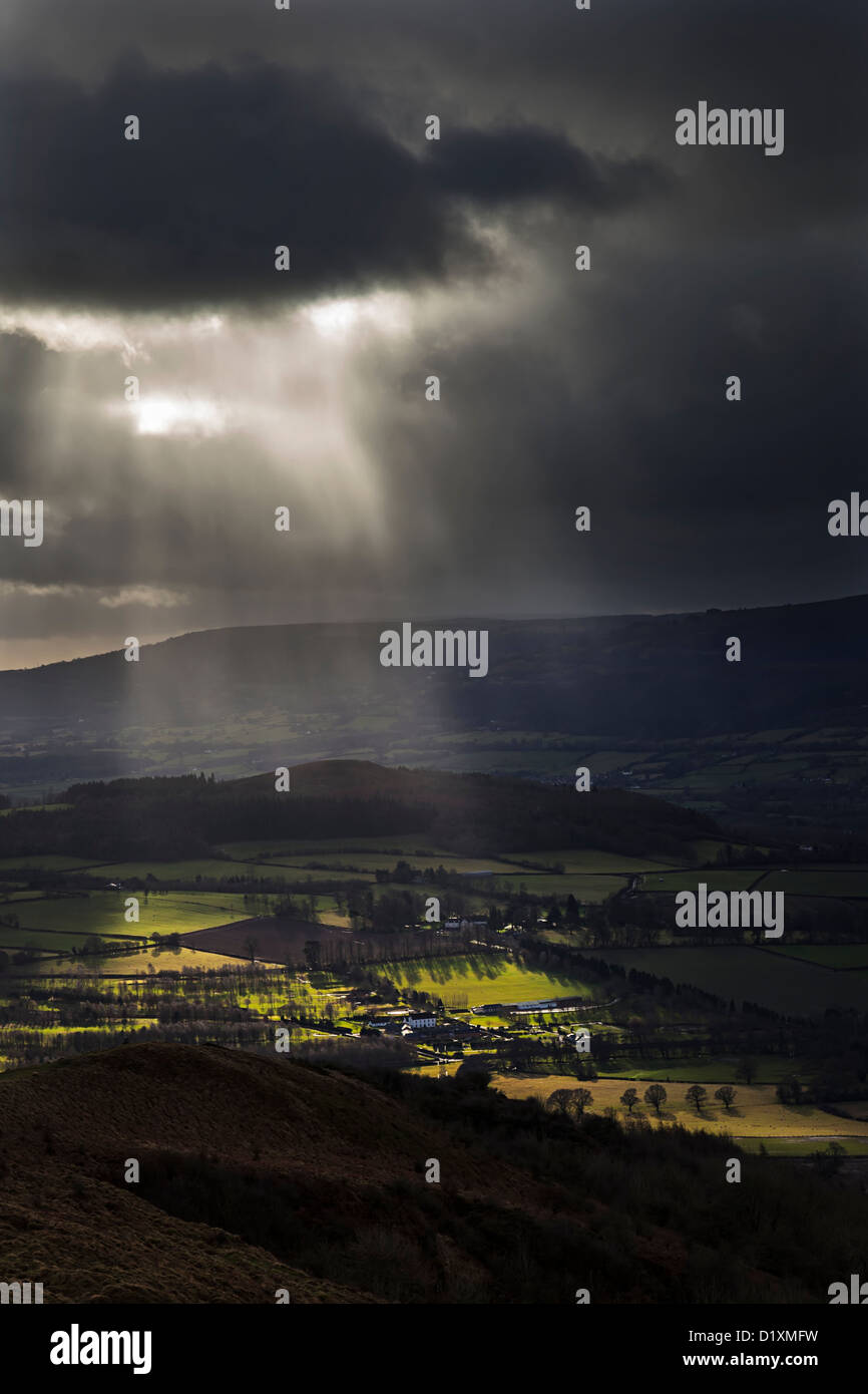 Dunkle Wolken mit Sonnenstrahlen über eine walisische Tal, Abergavenny, Wales, UK Stockfoto