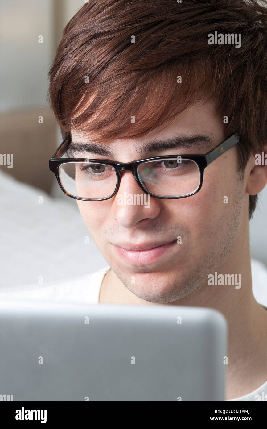 Junger Mann mit Brille, die einem Computer-Bildschirm betrachten. Stockfoto