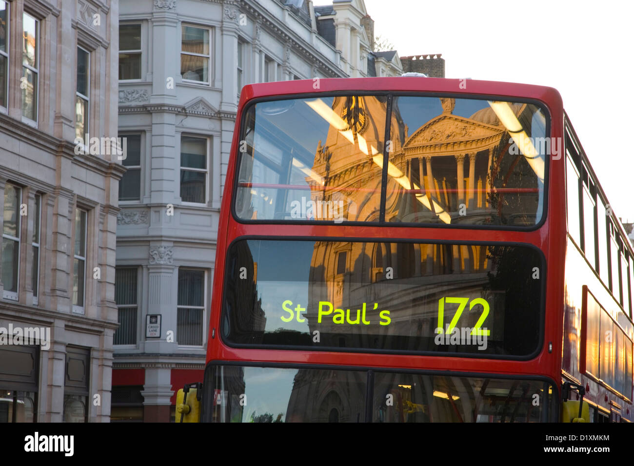 London, Greater London, England. St. Pauls Cathedral spiegelt sich im Fenster des traditionellen roten Doppeldeckerbus, Sonnenuntergang. Stockfoto