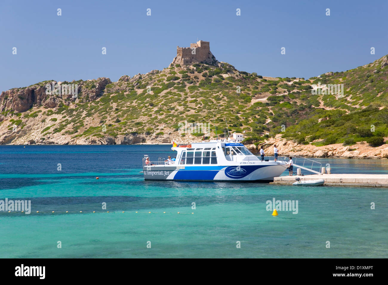 Insel Cabrera, Mallorca, Balearen, Spanien. Blick über die Bucht nach Schloss aus dem 14. Jahrhundert, Boot am Kai. Stockfoto