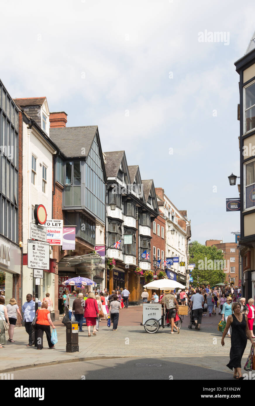 Pride Hill Einkaufsmeile, Shrewsbury beschäftigt an einem Sommertag mit Massen von Käufern. Eine Eis-Verkäufer wartet auf Kunden. Stockfoto