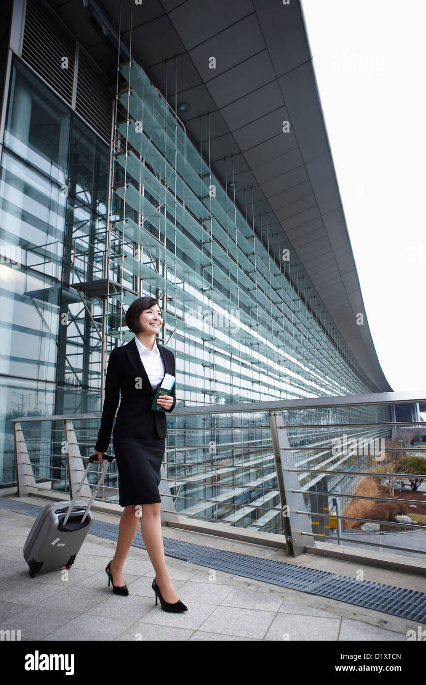 eine Geschäftsfrau mit einen Gepäck- und einen Pass zu Fuß in Incheon Flughafen Stockfoto