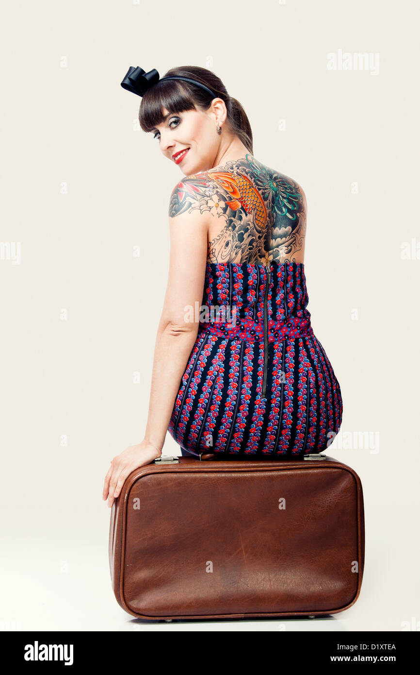Porträt einer schönen Frau mit einem Vintage-Stil sitzen über das Gepäck Stockfoto
