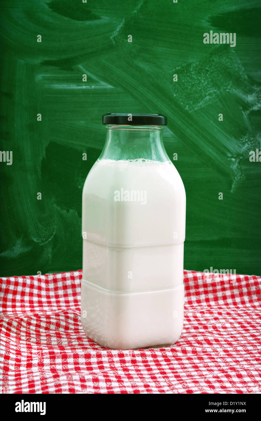 Eine Flasche Milch auf einem Küchentisch mit roten und weißen Tischdecke. Stockfoto
