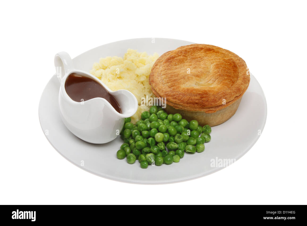 Herzhafte Kuchen mit Kartoffelpüree, Erbsen und Soße in einen Krug auf einem Teller isoliert gegen weiß Stockfoto