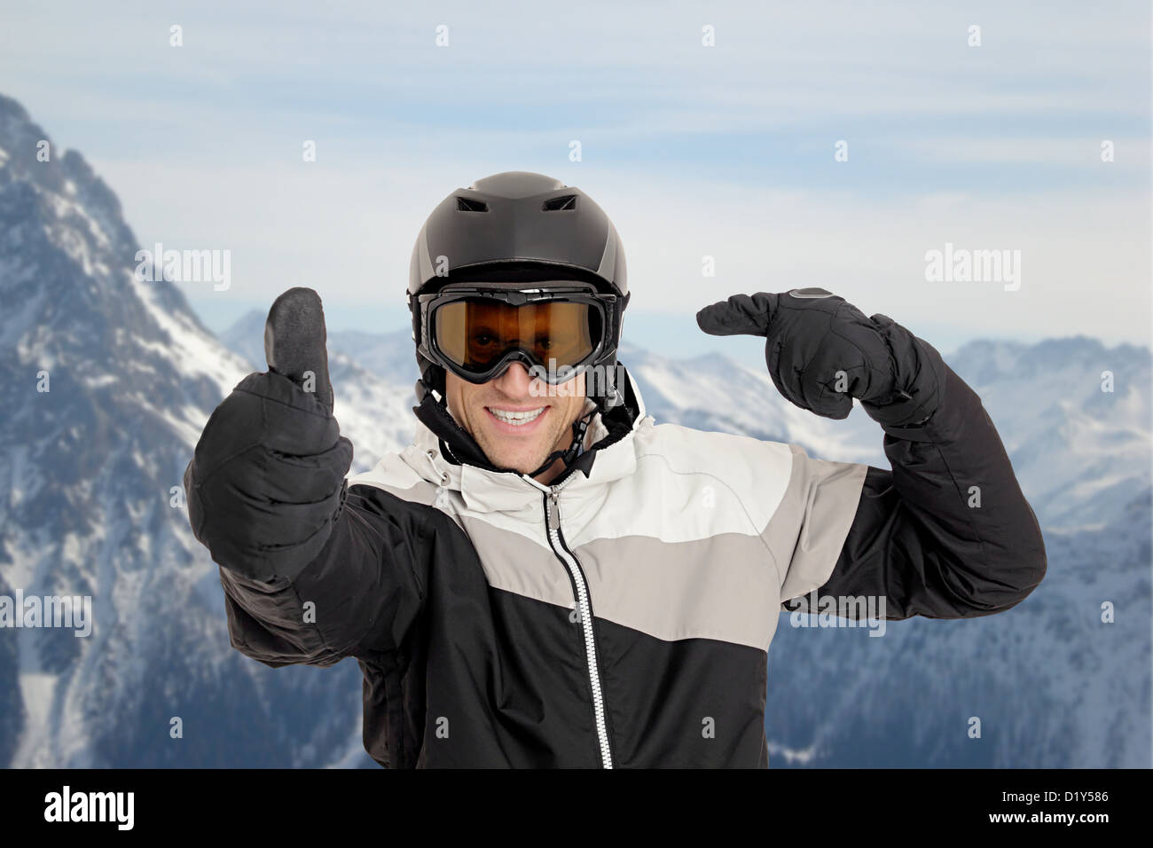 Skifahrer zeigt auf seinem Helm vor Bergen Stockfoto