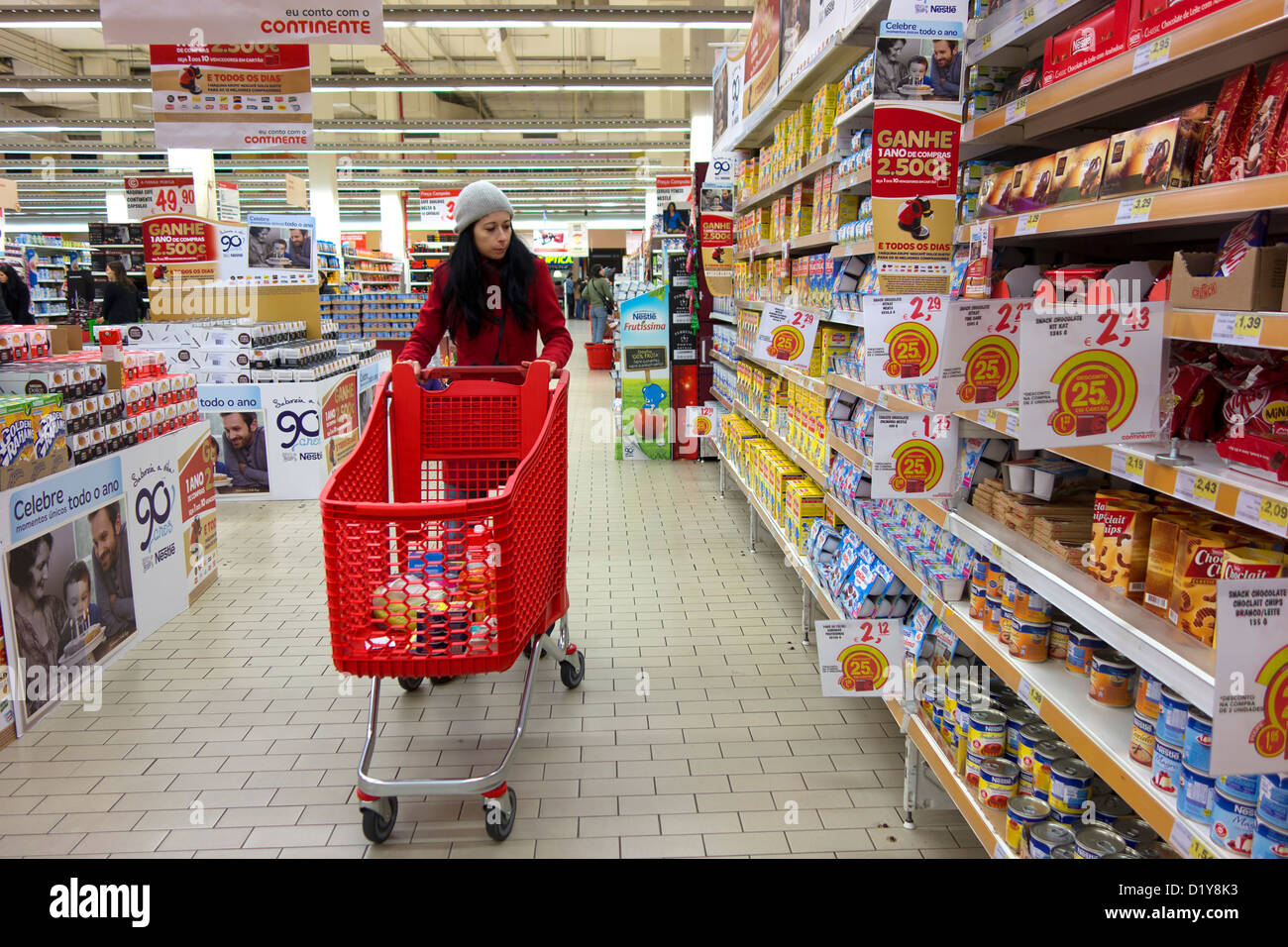 Frau im roten Mantel, Einkaufen im Supermarkt Gang Stockfoto