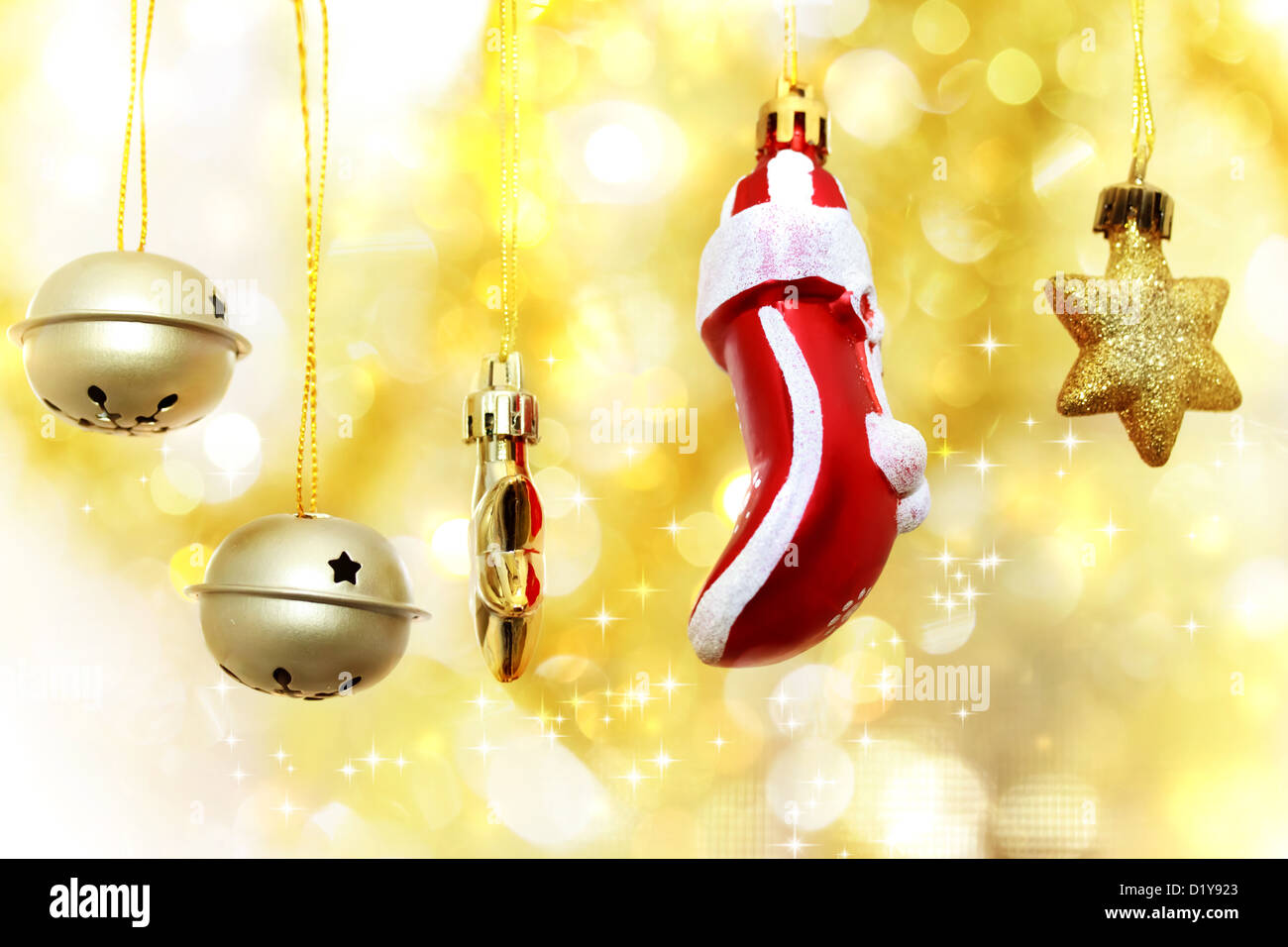 Weihnachtsglocken, Strumpf und Sterne über golden Bokeh Hintergrund hängen Stockfoto