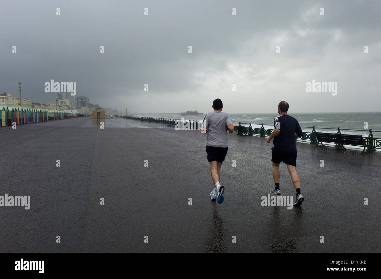 Jogger in Regen, Gewitterhimmel, Brighton seafront Stockfoto