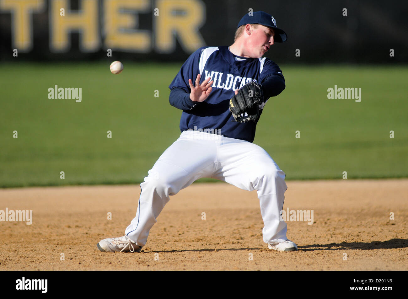 Baseball dritter Basisspieler kann einen harten Boden Kugel bei einem High School Spiel Feld an. USA. Stockfoto