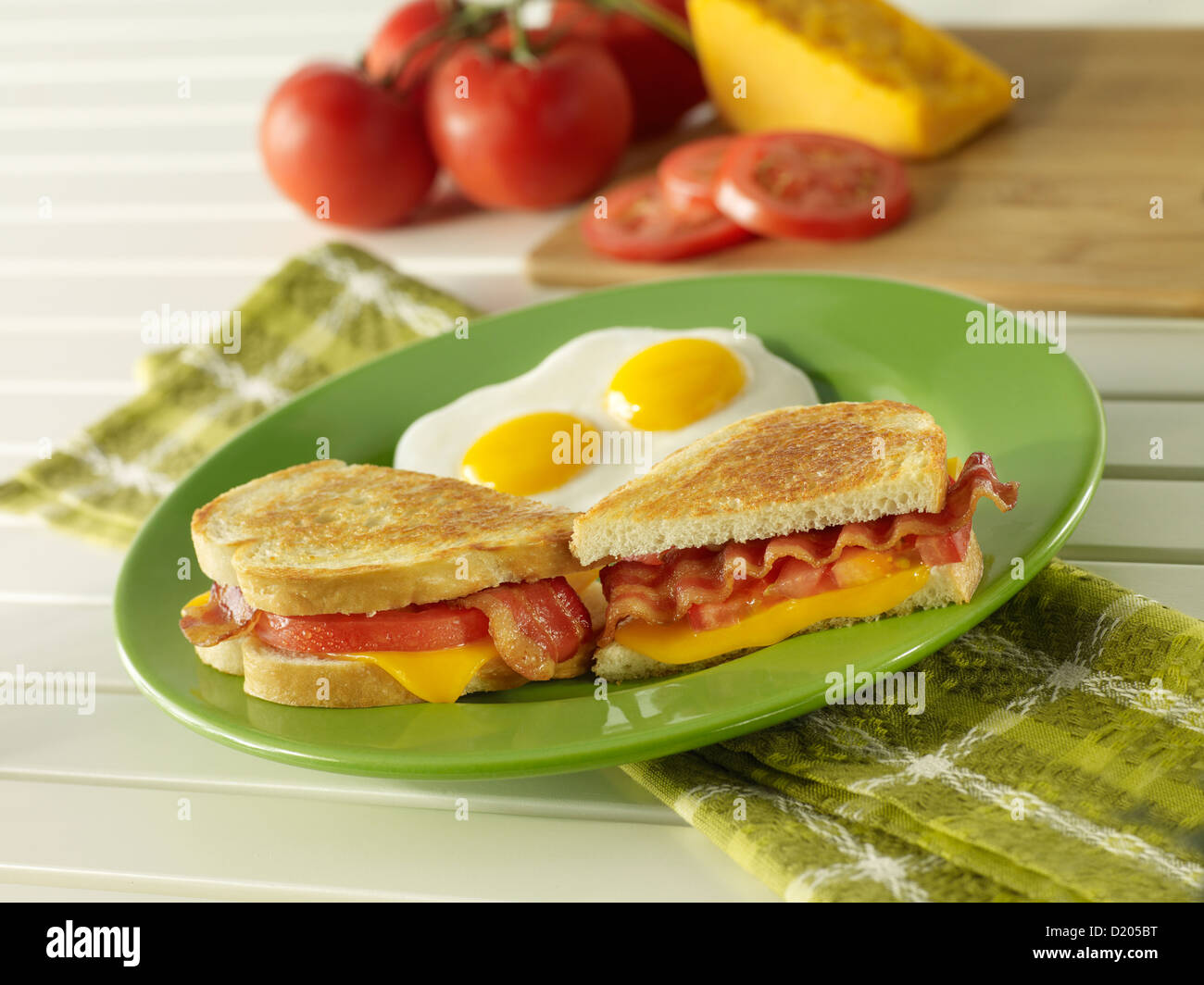 Gegrillter Speck, Käse und Tomaten-Frühstücks-Sandwich mit zwei Eiern sonnigen Seite nach oben Stockfoto