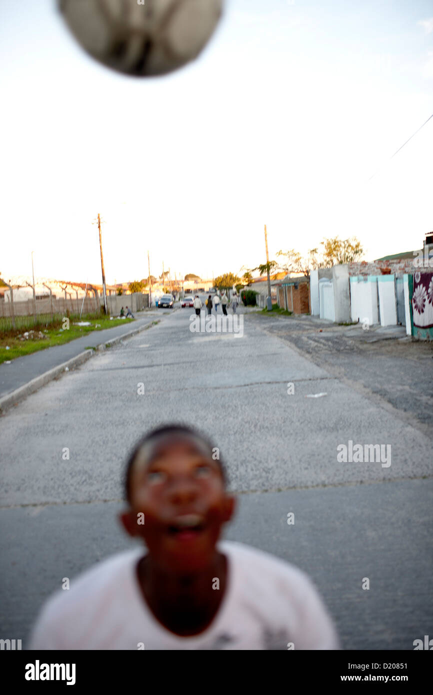 Junge mit Fußball auf der Straße vor Guguletu Township, Cape Flats, Cape Town, Südafrika, Afrika Stockfoto