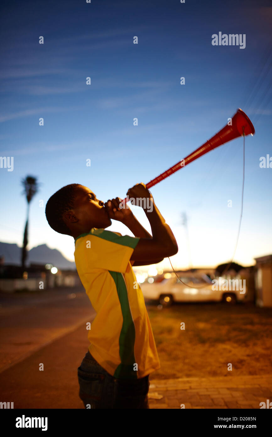 Jungen spielen Vuvuzela Horn in Guguletu Township am Abend, Cape Flats, Cape Town, Südafrika, Afrika Stockfoto
