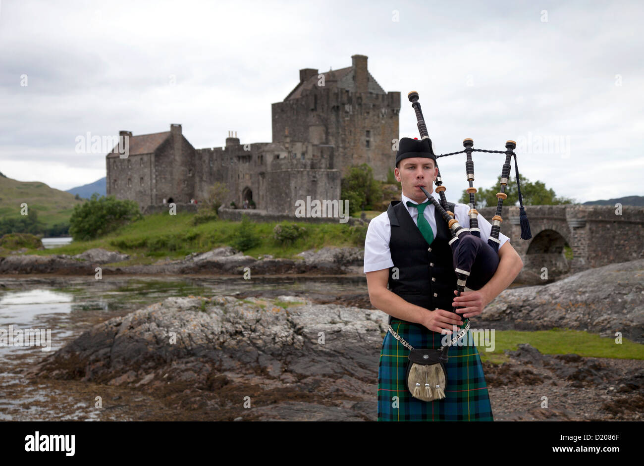 Dornie, Vereinigtes Königreich, Dudelsackspieler vor Eilean Donan Castle am Loch Duich Stockfoto